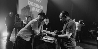 Concert techno avec artistes sur scène.