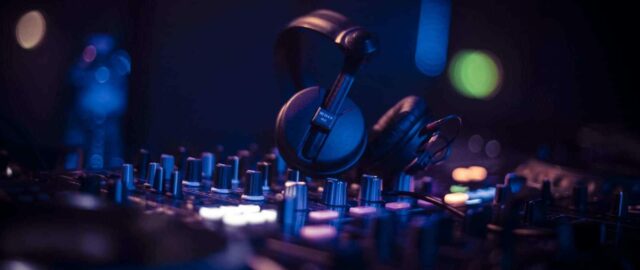 Casque audio sur console DJ en éclairage bleu