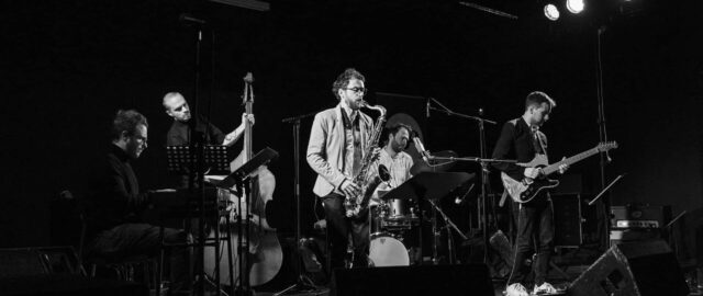 Groupe de musiciens jouant sur scène, ambiance jazz.