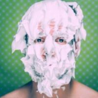 Homme couvert de mousse à raser visage.