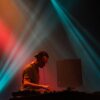 DJ mixant sous lumières colorées sur scène.