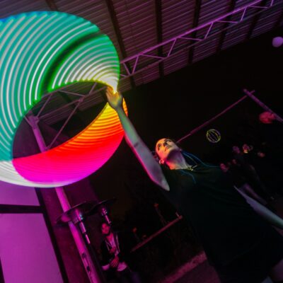 Personne jonglant avec cercle lumineux coloré.