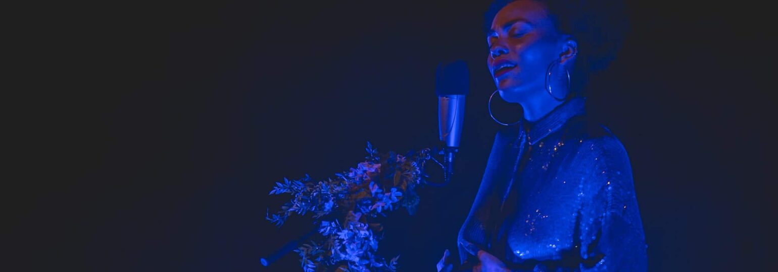 Chanteuse sur scène, éclairage bleu artistique