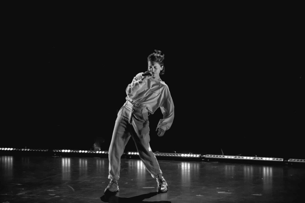 Personne chante sur scène dans l'obscurité.