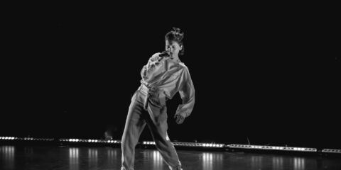 Personne chante sur scène dans l'obscurité.