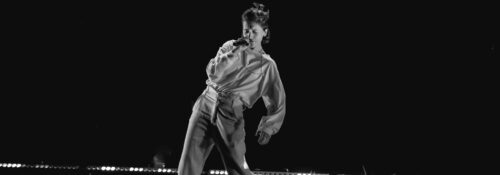 Personne chante sur scène dans l'obscurité.