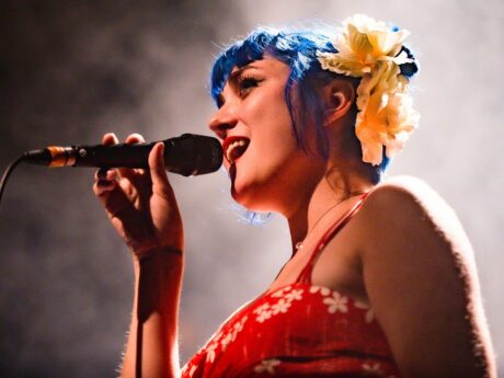 Chanteuse sur scène avec micro et cheveux bleus