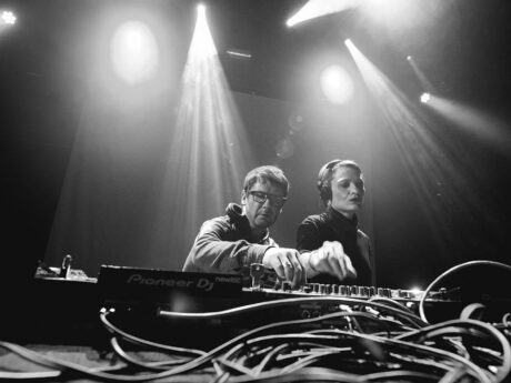 Deux DJ mixant sur scène, éclairage intense.