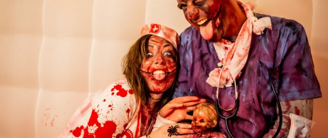 Deux personnes déguisées en médecins zombies sanglants.