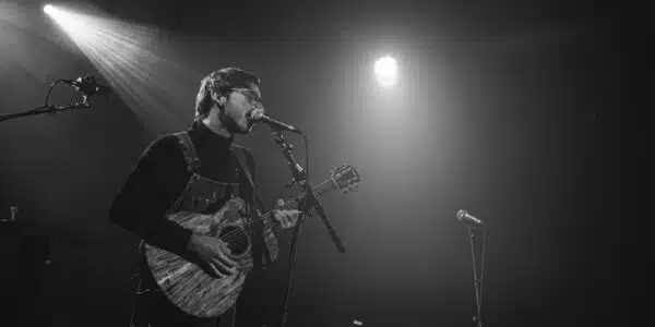 Chanteur jouant de la guitare sur scène.