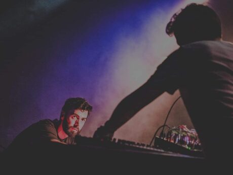 Concert électro avec lumière colorée et musique live.