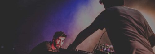 Concert électro avec lumière colorée et musique live.