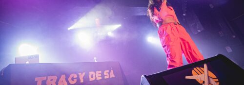 Chanteuse sur scène avec éclairage violet vif.