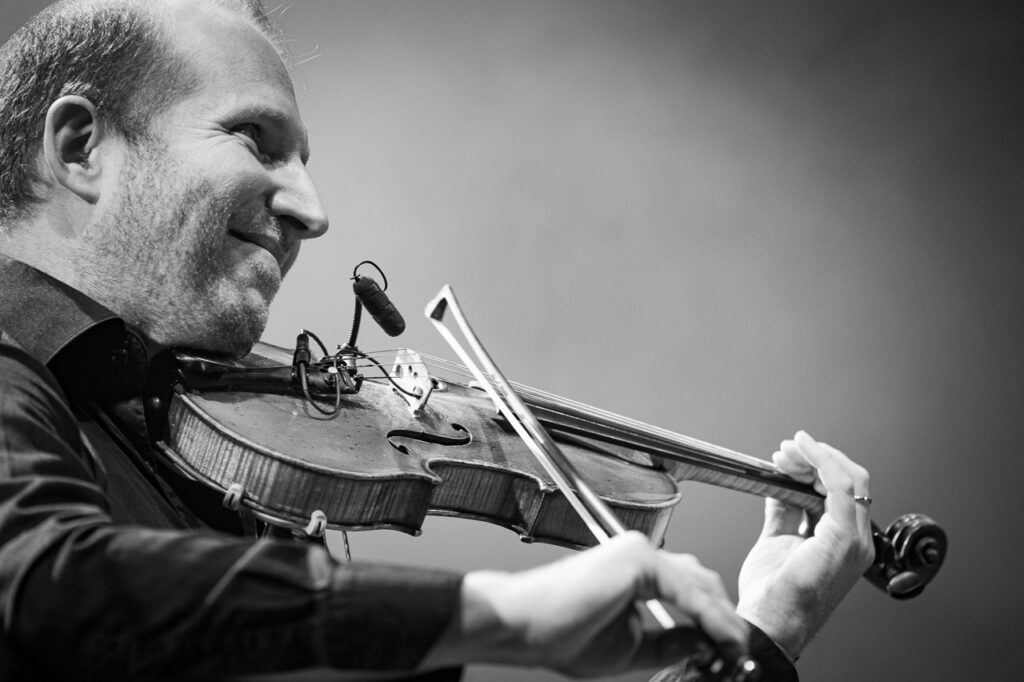 Homme jouant du violon sur scène.