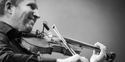 Homme jouant du violon sur scène.