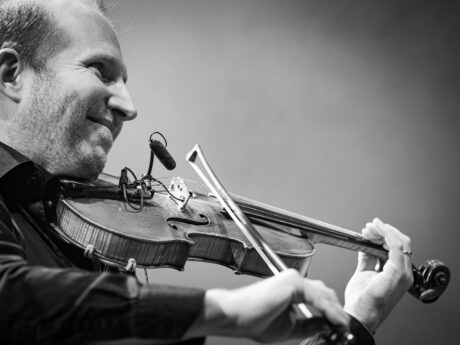 Homme jouant du violon sur scène.