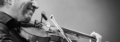 Homme jouant du violon sur scène.