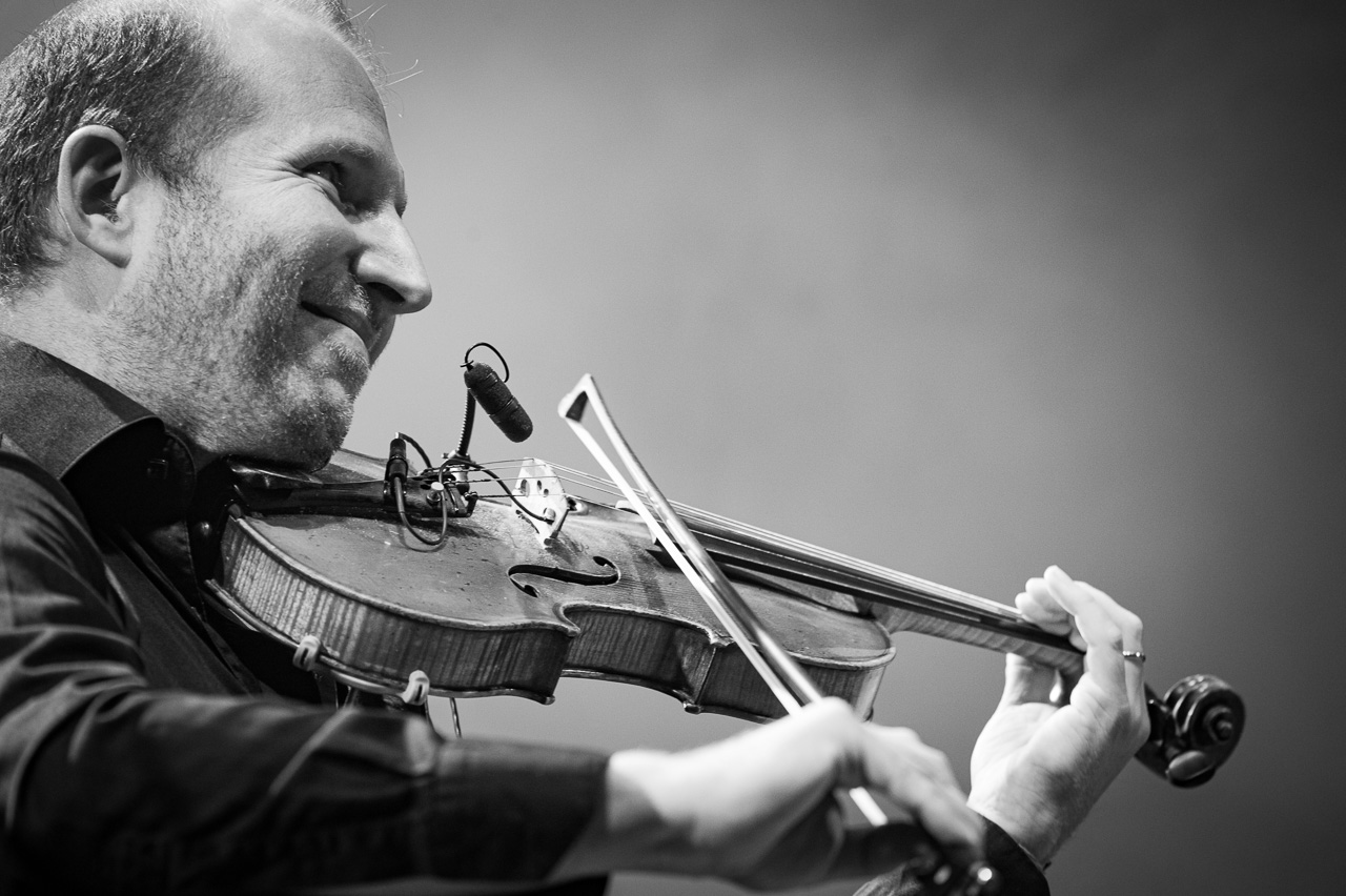 Homme jouant du violon sur scène.