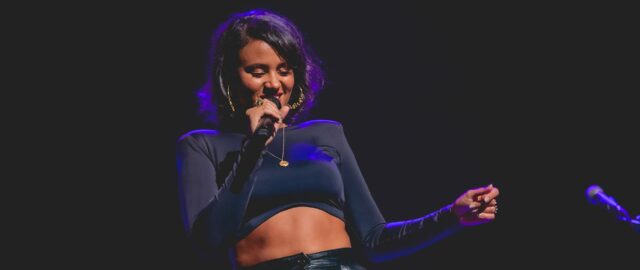 Femme chantant sur scène en concert.