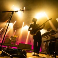 Groupe de musique en concert avec éclairage coloré.