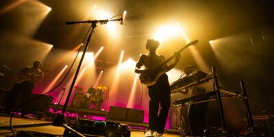 Groupe de musique en concert avec éclairage coloré.