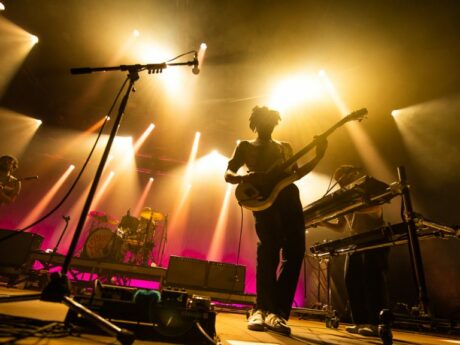 Groupe de musique en concert avec éclairage coloré.