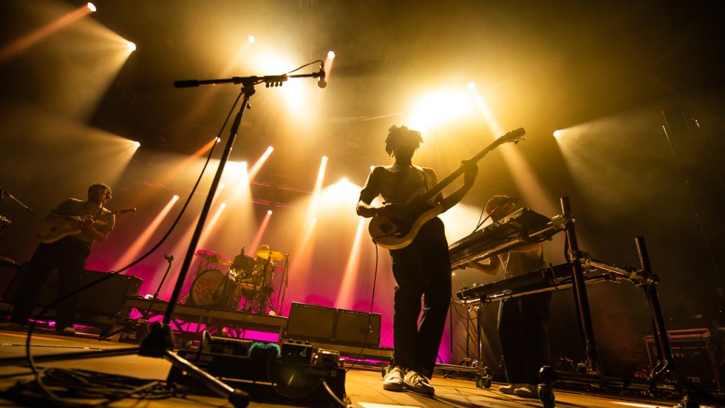 Groupe de musique en concert avec éclairage coloré.