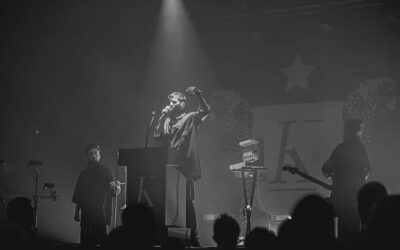 Concert en noir et blanc, chanteur sur scène.