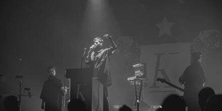 Concert en noir et blanc, chanteur sur scène.