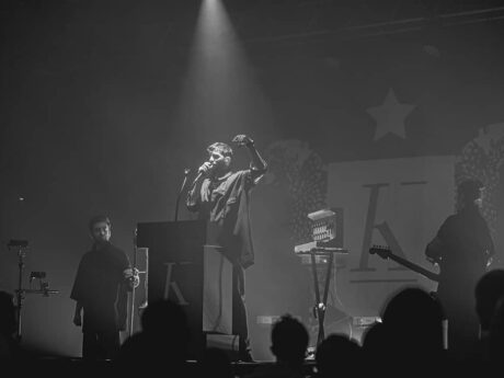 Concert en noir et blanc, chanteur sur scène.