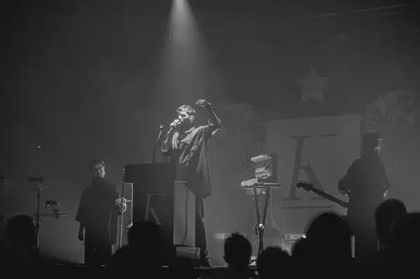 Concert en noir et blanc, chanteur sur scène.