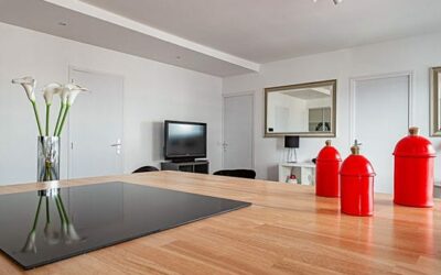 Cuisine moderne avec îlot et décoration rouge.