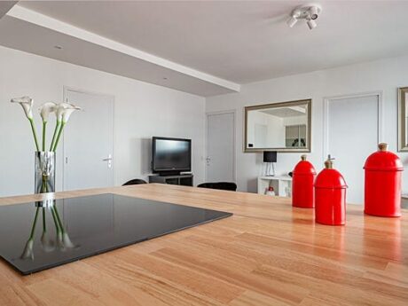 Cuisine moderne avec îlot et décoration rouge.