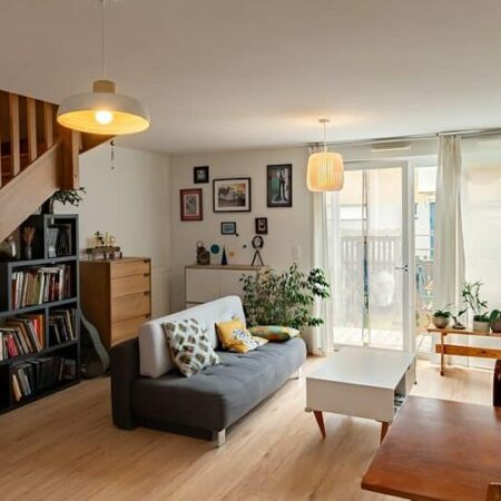 Salon moderne avec escalier et plantes.