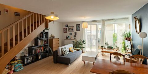 Salon moderne avec escalier et plantes.