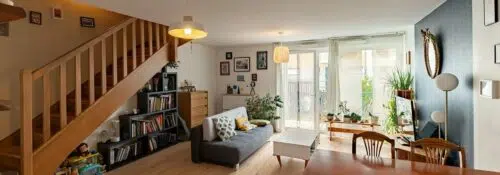 Salon moderne avec escalier et plantes.