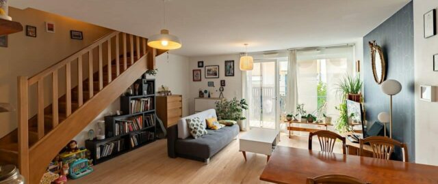 Salon moderne avec escalier et plantes.