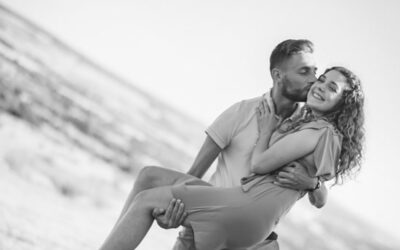 Couple s'embrassant en extérieur, homme portant femme.