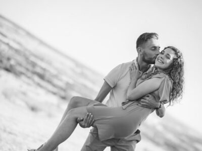 Couple s'embrassant en extérieur, homme portant femme.