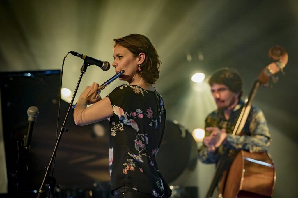 Concert avec flûtiste et contrebassiste sur scène.