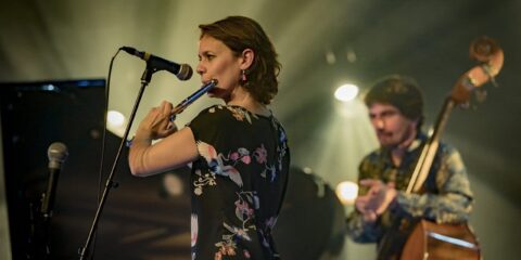 Concert avec flûtiste et contrebassiste sur scène.