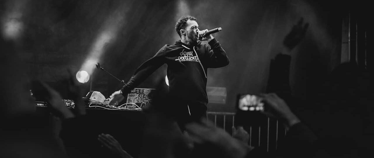 Rappeur sur scène avec micro, noir et blanc