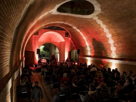 Concert dans une voûte éclairée en rouge.