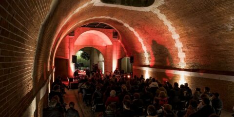 Concert dans une voûte éclairée en rouge.