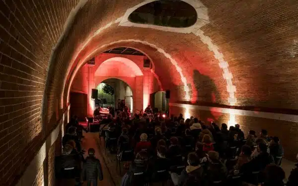 Concert dans une voûte éclairée en rouge.