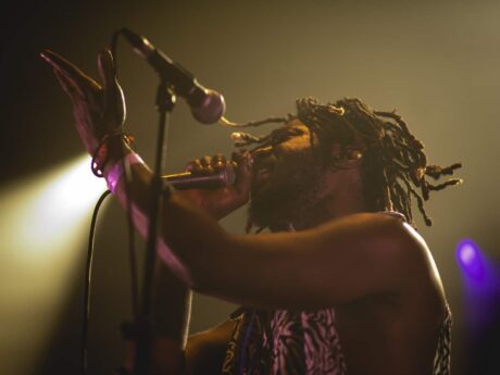 Chanteur sur scène avec micro et projecteurs.