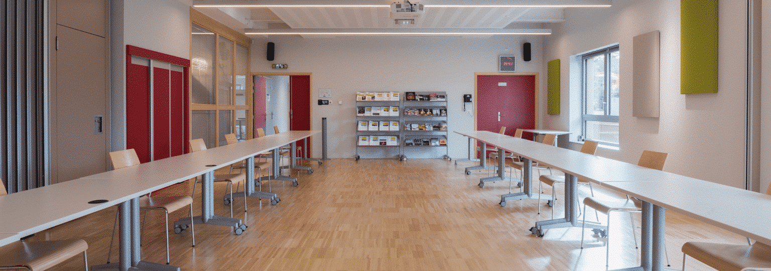 Salle de réunion avec tables et chaises modernes.