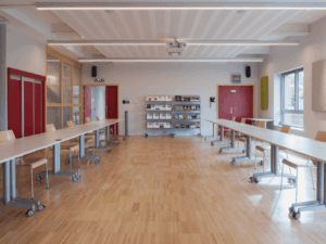 Salle de réunion avec tables et chaises modernes.