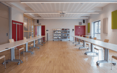 Salle de réunion avec tables et chaises modernes.