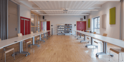 Salle de réunion avec tables et chaises modernes.
